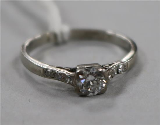A mid 20th century platinum and single stone diamond ring with diamond set shoulders, size O.